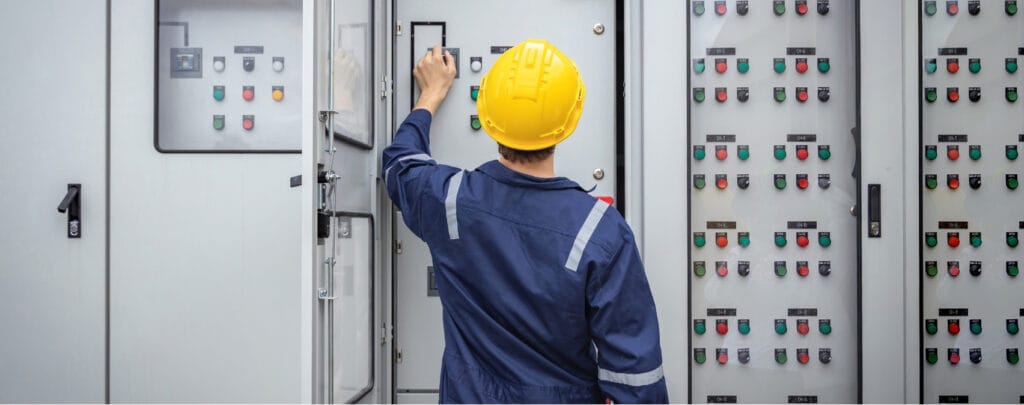 Técnico con casco revisando un cuadro eléctrico de baja tensión