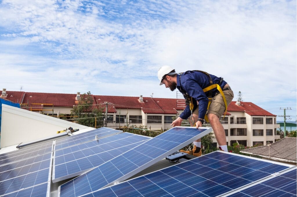 Instalador montando placas solares en una cubierta