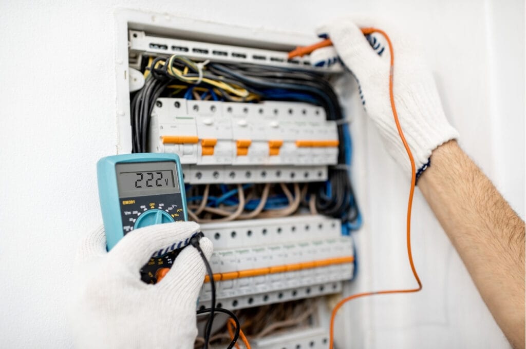 Instalador eléctrico midiendo con multímetro en un cuadro de protecciones